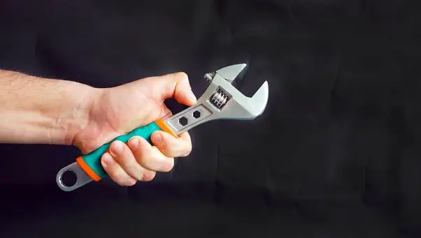 man hand holding adjustable wrench
