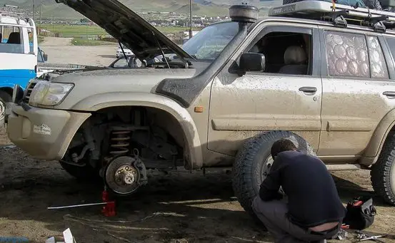 man repairing a car that has broken down
